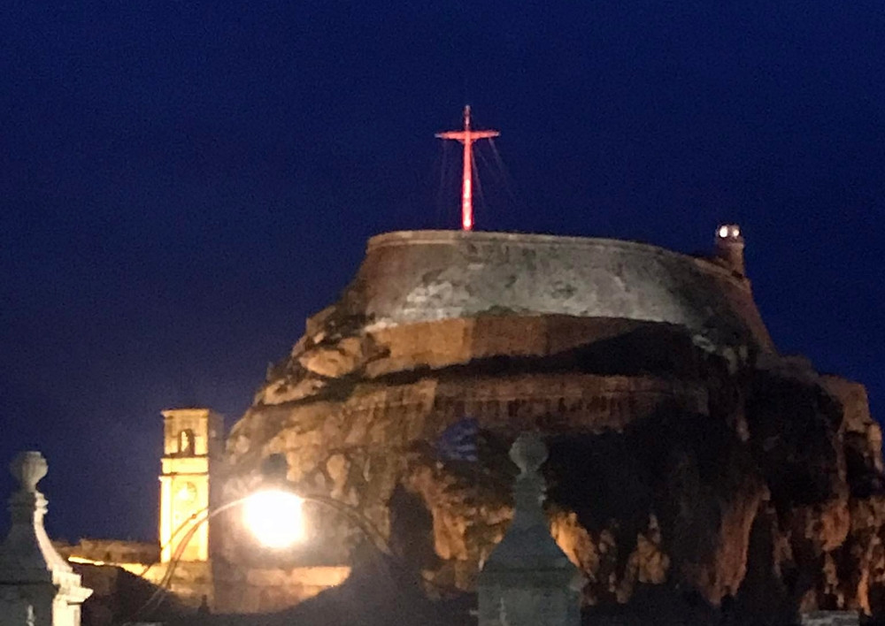Old Fortress cross lit up in orange against domestic violence